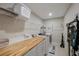 Functional laundry room with butcher block countertop, washer, dryer, and shelving provides a convenient space for laundry tasks at 6031 Grand Sonata Ave, Lutz, FL 33558