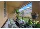 Comfortable outdoor seating on a covered patio with plants and a view of the manicured lawn at 6031 Grand Sonata Ave, Lutz, FL 33558