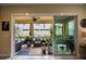 Relaxing covered patio with stone flooring, ceiling fan, and comfortable seating area overlooking the backyard at 6031 Grand Sonata Ave, Lutz, FL 33558