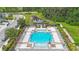 Aerial view of the community pool surrounded by lounge chairs, umbrellas, lush landscaping, and serene pond at 6031 Grand Sonata Ave, Lutz, FL 33558
