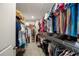 Organized walk-in closet featuring shelves and hanging rods provides ample storage space for clothes and accessories at 6031 Grand Sonata Ave, Lutz, FL 33558