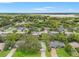 Expansive aerial view of a residential area with lush greenery, homes, and a glimpse of a serene lake at 6058 Waycross Dr, Spring Hill, FL 34606