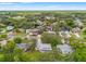 Elevated view of a neighborhood with mature trees, houses, and a network of roads under a bright sky at 6058 Waycross Dr, Spring Hill, FL 34606
