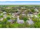 Elevated view of a neighborhood with mature trees, houses, and a network of roads under a bright sky at 6058 Waycross Dr, Spring Hill, FL 34606