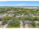 Expansive aerial view of a residential area with lush greenery, homes, and a glimpse of a serene lake at 6058 Waycross Dr, Spring Hill, FL 34606