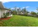 Green backyard features a spacious lawn, bordered by plants, a fence, and the home's screened-in porch at 6058 Waycross Dr, Spring Hill, FL 34606