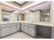 Spacious bathroom with a double vanity, tiled floor, and large mirror with decorative trim at 6058 Waycross Dr, Spring Hill, FL 34606