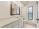 Bathroom features large mirror, vanity with storage, and window for natural light at 6058 Waycross Dr, Spring Hill, FL 34606