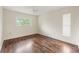 Bright bedroom features hardwood floors, a ceiling fan, and two windows allowing natural light at 6058 Waycross Dr, Spring Hill, FL 34606