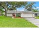 Charming single-story home featuring a well-manicured lawn, mature trees and a two-car garage at 6058 Waycross Dr, Spring Hill, FL 34606