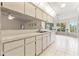 Bright kitchen with white cabinets, updated appliances, and an open view to the adjacent living area at 6058 Waycross Dr, Spring Hill, FL 34606