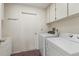 Functional laundry room with washer, dryer, utility sink, and storage cabinets for convenience at 6058 Waycross Dr, Spring Hill, FL 34606