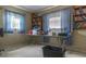 This bedroom features blue curtains, beige walls, and bookshelves, creating a cozy yet spacious atmosphere at 6405 2Nd Palm Pt, St Pete Beach, FL 33706