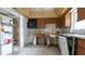 A kitchen with wooden cabinets awaits remodel, featuring a bright window and a functional layout at 6405 2Nd Palm Pt, St Pete Beach, FL 33706