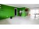 Spacious living room with bright green walls, a vintage sewing machine, and abundant natural light at 6405 2Nd Palm Pt, St Pete Beach, FL 33706