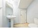 Compact half-bathroom features a pedestal sink, toilet and light tile flooring at 7410 E Bank Dr, Tampa, FL 33617