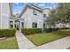 Charming exterior townhome with manicured green lawn, pathway and lovely neutral paint at 7410 E Bank Dr, Tampa, FL 33617