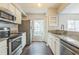 Well-lit kitchen with stainless steel appliances, granite countertops, and white cabinetry at 7410 E Bank Dr, Tampa, FL 33617