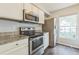 Cozy kitchen featuring modern stainless steel appliances and granite countertops at 7410 E Bank Dr, Tampa, FL 33617