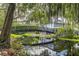 Scenic community pond with bridge and lush foliage provides a tranquil setting at 7410 E Bank Dr, Tampa, FL 33617