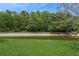 A picturesque backyard view features a lush lawn, mature trees, and a canal at 8549 Pinafore Dr, New Port Richey, FL 34653