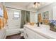 Bathroom with tile flooring, decorative plants, white vanity, and shower-tub combination with a green shower curtain at 8549 Pinafore Dr, New Port Richey, FL 34653