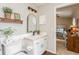 Bathroom with a white vanity with a pink countertop and decorative wall shelf, plus a doorway view to the bedroom at 8549 Pinafore Dr, New Port Richey, FL 34653
