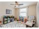 Bright bedroom with a ceiling fan and light fixture, featuring a large shelving unit and window with white blinds at 8549 Pinafore Dr, New Port Richey, FL 34653