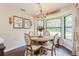 Cozy dining area featuring a wooden table, cushioned chairs, chandelier lighting, and a bay window at 8549 Pinafore Dr, New Port Richey, FL 34653