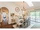 Dining room with a modern chandelier, bar seating, and an open view to the kitchen at 8549 Pinafore Dr, New Port Richey, FL 34653