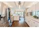 Spacious kitchen with white cabinetry, stainless steel refrigerator, and an adjacent dining area with large windows at 8549 Pinafore Dr, New Port Richey, FL 34653