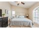 Bright main bedroom with vaulted ceilings, tufted headboard, neutral walls and a ceiling fan with light fixture at 8549 Pinafore Dr, New Port Richey, FL 34653