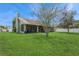 The backyard boasts a large lawn, mature tree, and a screened in porch at 8549 Pinafore Dr, New Port Richey, FL 34653