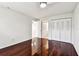 Bright bedroom featuring dark hardwood floors, closet, and ceiling fan at 9142 Oakwood Ln, Seminole, FL 33776
