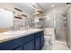 Elegant bathroom with double vanity, blue cabinets, and glass shower at 962 Sombra St, Tampa, FL 33619