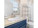 Well-lit bathroom featuring a blue vanity with a sleek countertop and a modern sink at 962 Sombra St, Tampa, FL 33619