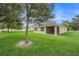 Expansive backyard, lush lawn, partial shade trees, and a screened lanai on a sunny day at 9724 Troncais Cir, Thonotosassa, FL 33592