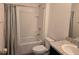 Well-lit bathroom featuring a shower-tub combo, tile surround, and modern fixtures and toilet at 9724 Troncais Cir, Thonotosassa, FL 33592
