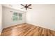 Cozy bedroom featuring wood floors, a ceiling fan, and a bright window at 9724 Troncais Cir, Thonotosassa, FL 33592