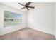 Bright bedroom featuring carpet flooring, a ceiling fan, and a bright window at 9724 Troncais Cir, Thonotosassa, FL 33592