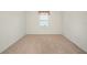 Spacious carpeted bedroom with bright window providing natural light and electrical outlets at 9724 Troncais Cir, Thonotosassa, FL 33592
