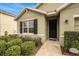 A cozy single-Gathering home with a black front door, black shutters, and meticulously maintained landscaping at 9724 Troncais Cir, Thonotosassa, FL 33592