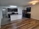 Modern kitchen featuring stainless steel appliances, granite countertops, and stylish cabinetry with a view to the living area at 9724 Troncais Cir, Thonotosassa, FL 33592