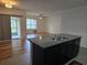 Open-concept kitchen with granite countertops flows into a spacious living area with sliding doors to the lanai at 9724 Troncais Cir, Thonotosassa, FL 33592