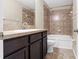 Bathroom features a soaking tub with tiled shower and a dark wood vanity with white sink at 9752 Trumpet Vine Loop, Trinity, FL 34655