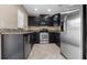 Kitchen with stainless steel appliances, dark cabinets, and tile flooring at 9752 Trumpet Vine Loop, Trinity, FL 34655