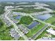 Aerial view of residential community with lakes, homes, and green spaces at 10347 Heron Hideaway Loop, Land O Lakes, FL 34638