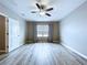 Bedroom with light wood flooring, fan, neutral walls, and a window with blinds and curtains at 10347 Heron Hideaway Loop, Land O Lakes, FL 34638