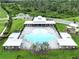 Aerial view of community pool area featuring a large pool, shaded seating, and playground at 10347 Heron Hideaway Loop, Land O Lakes, FL 34638