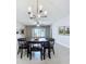 Dining room with contemporary chandelier, fan and sliding glass doors offering a view of the water at 10347 Heron Hideaway Loop, Land O Lakes, FL 34638